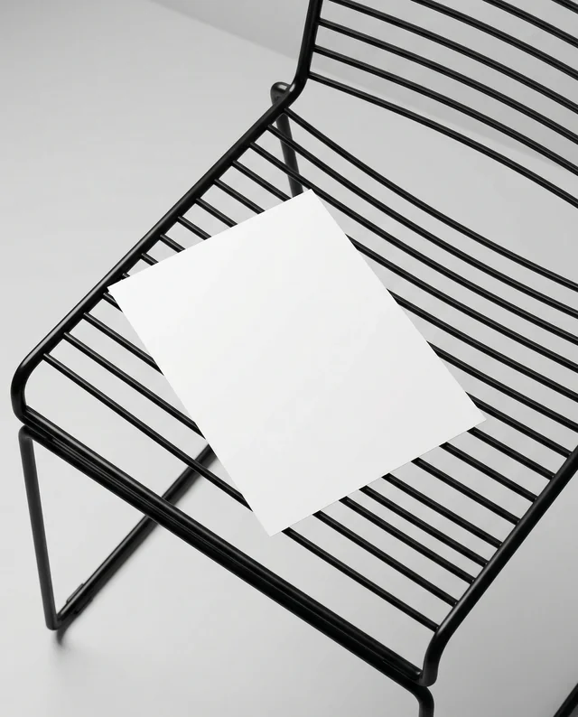 Minimalist Mockup of a Flyer on a Sleek Black Chair