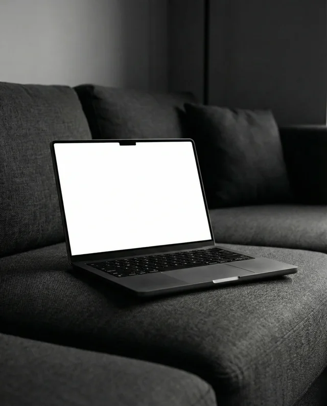 Minimalist MacBook Mockup on Dark Gray Sofa