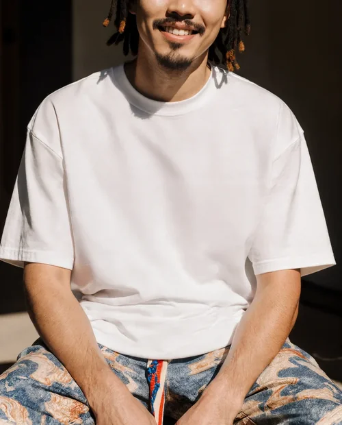 Casual T-Shirt Mockup of a Young Man in Sunlit Setting