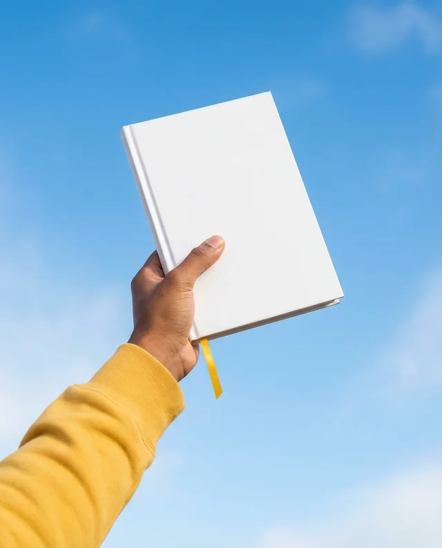 Mockup of a Book in Hand Against a Blue Sky
