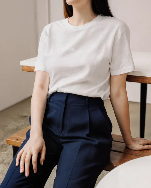 Stylish T-Shirt Mockup of a Young Woman in Minimalist Setting