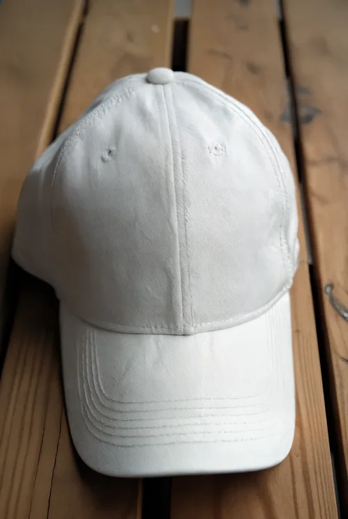 Stylish Mockup of a White Hat on Rustic Wood