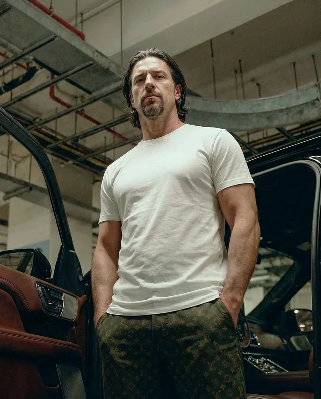 Stylish T-Shirt Mockup with Confident Man in Garage