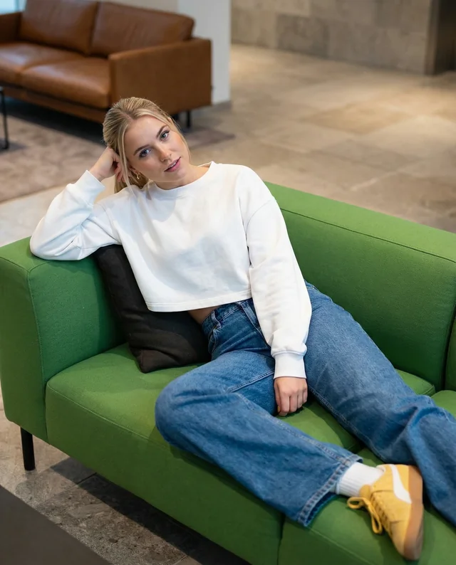 Stylish Mockup of a Woman in a Crop Top on Sofa