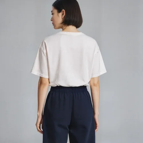 Mockup of T-Shirt in Soft Beige Against Gray Background