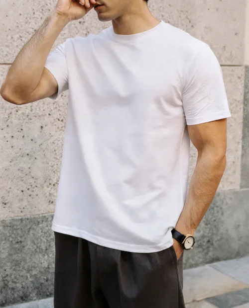 Stylish T-Shirt Mockup of a Young Man Against Wall