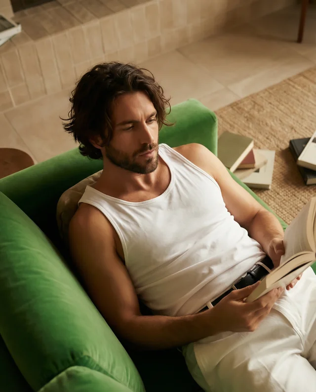 Relaxed Young Man in White Tank Top Reading on Couch