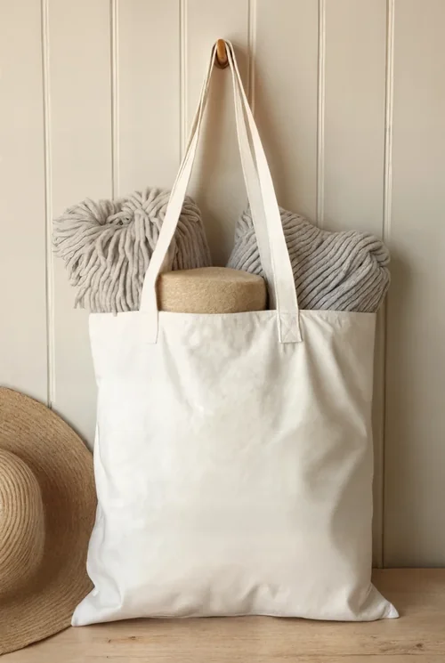 Cozy Mockup of a Cream Tote Bag with Yarn and Hat