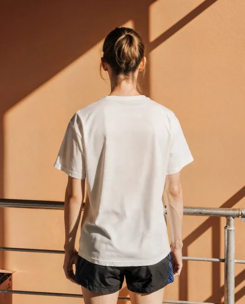 Casual T-Shirt Mockup Against Warm Peach Wall