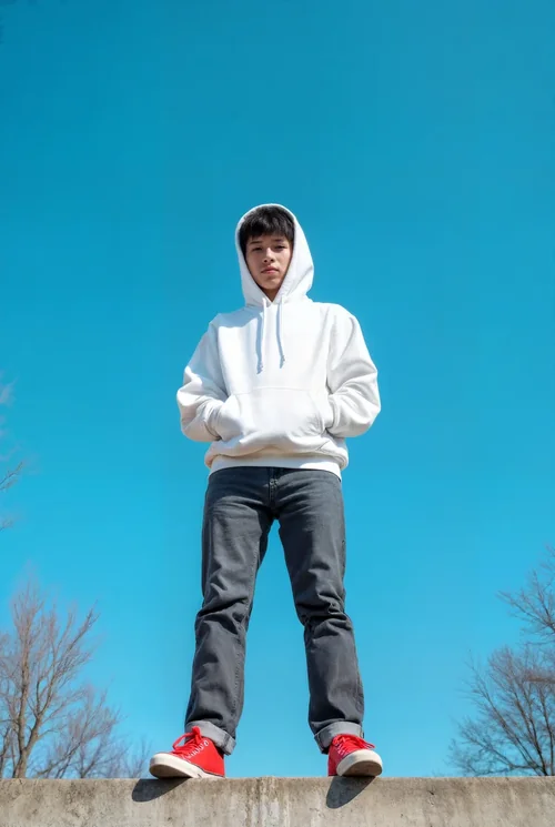 Vibrant Hoodie Mockup Against Clear Blue Sky and Trees