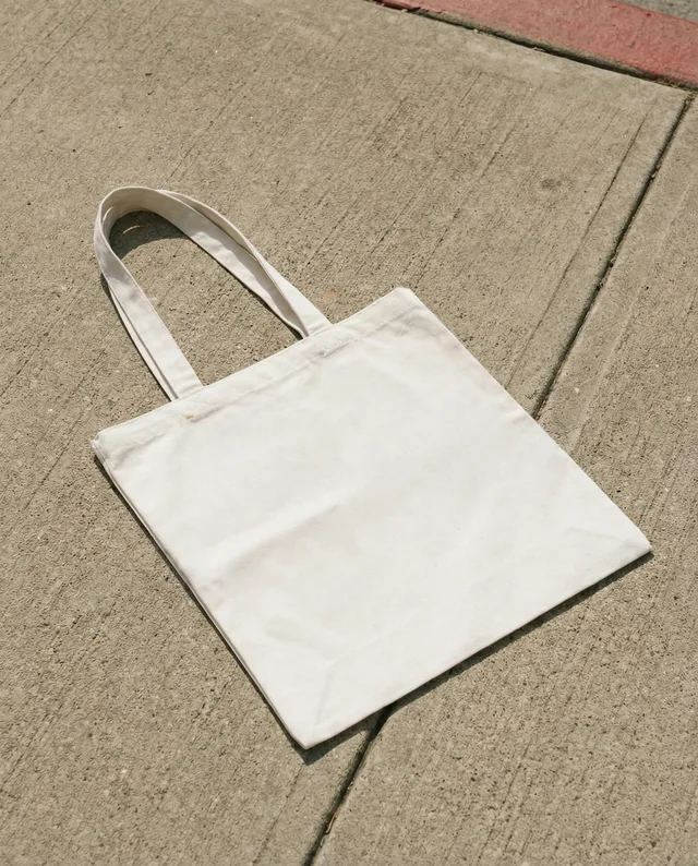 Minimalist Mockup of a White Tote Bag on Concrete