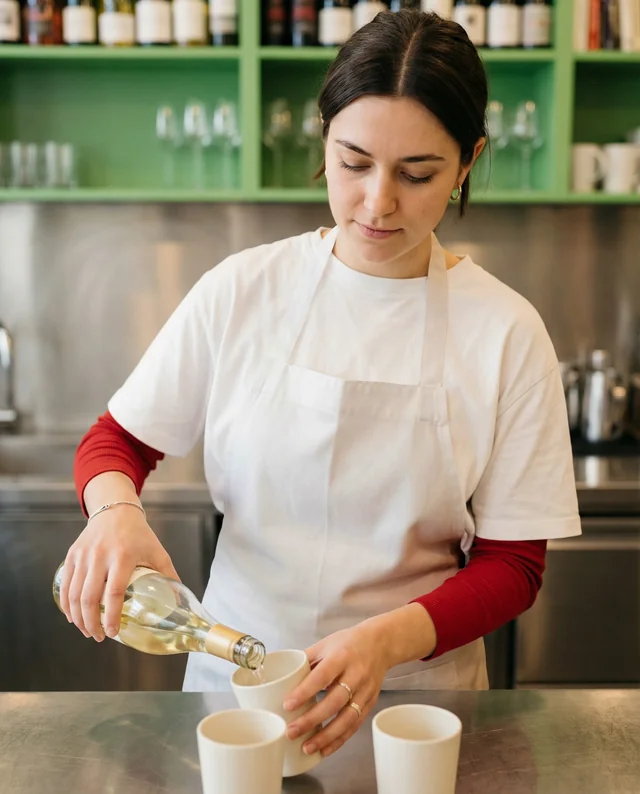 Young Woman Pouring Wine with Stylish Apron Mockup