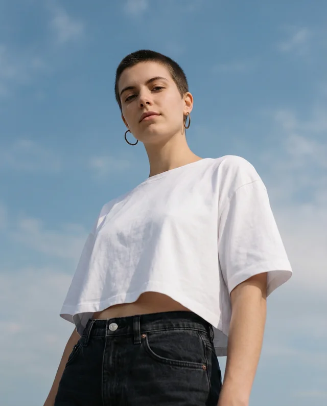 Confident Young Person in Crop Top Mockup Against Sky