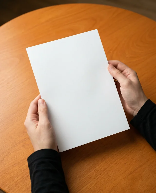 Elegant Mockup of Hands Holding a Blank Flyer Above Table