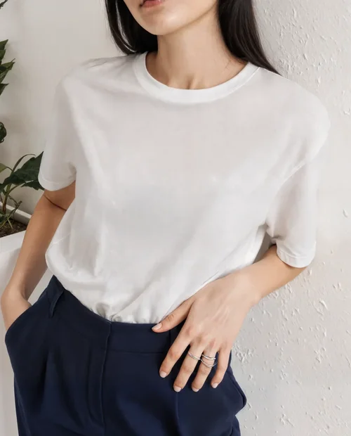 Stylish T-Shirt Mockup of a Young Woman in Minimalist Space