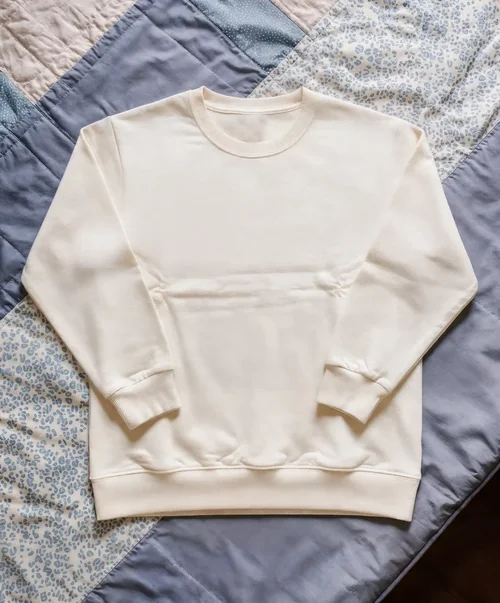 Cream Sweatshirt Mockup on Cozy Quilted Blanket