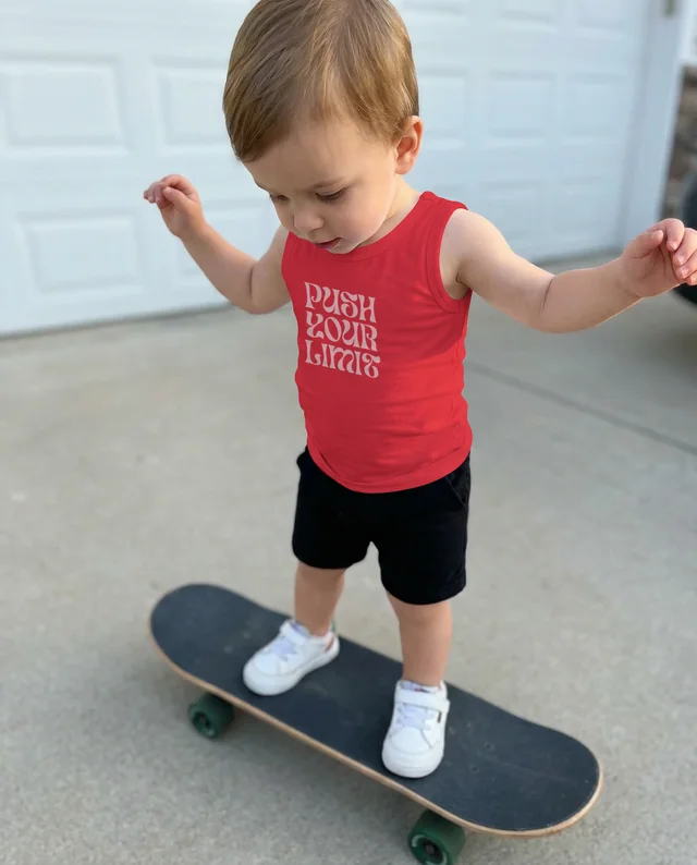 Confident Child on Skateboard in Snug White Tank Top
