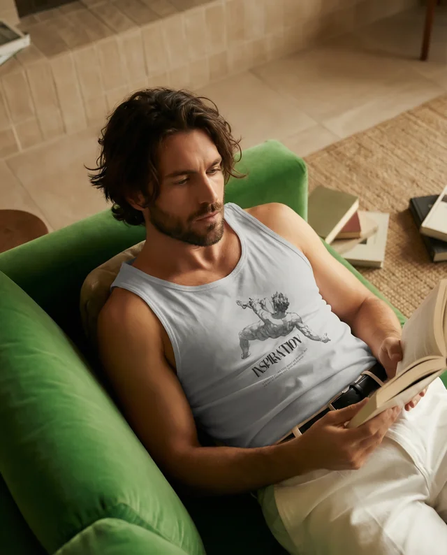 Relaxed Young Man in White Tank Top Reading on Couch